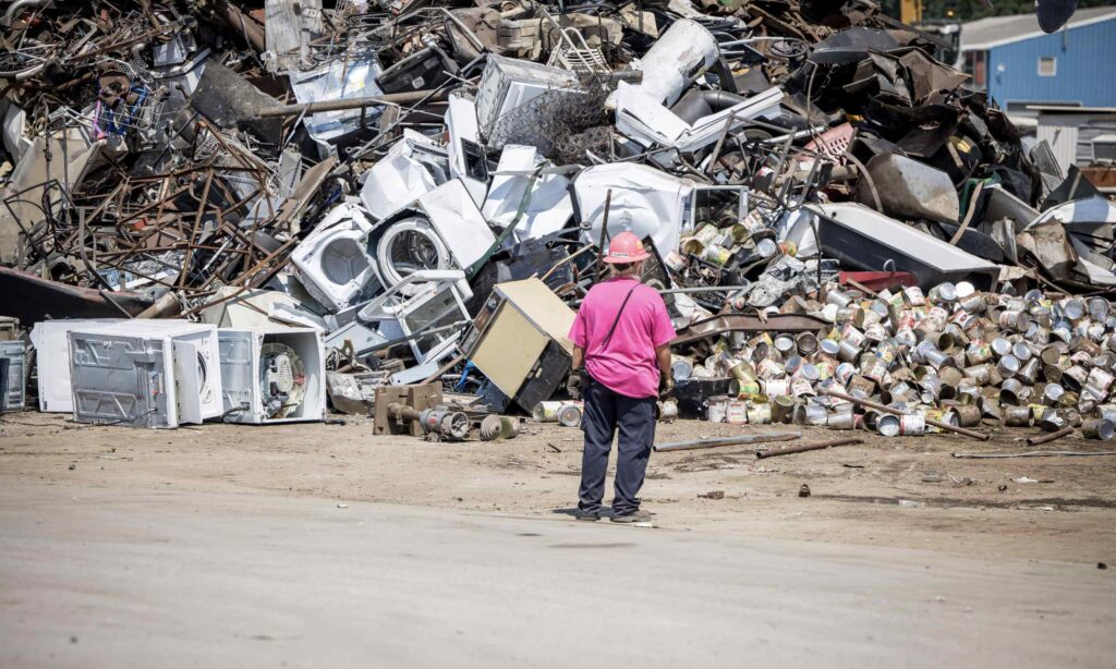 worker standing in front of recycling pile